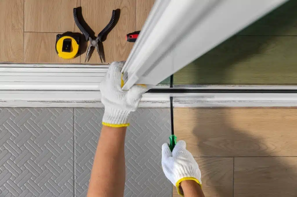 Technician replacing worn rollers on sliding glass door in Austin home